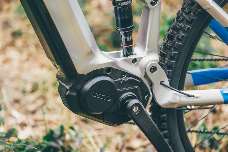 Detailed view of an electric mountain bike crank arm and frame outdoors
