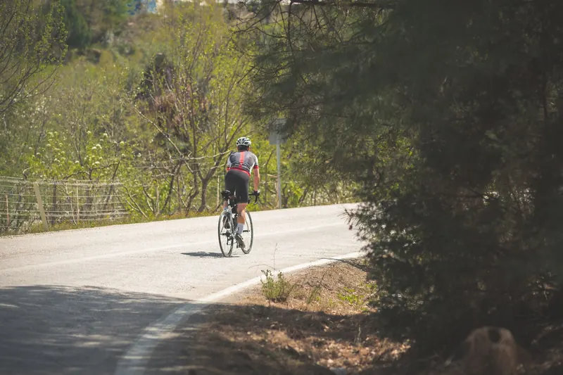 A cyclist riding on a scenic road in Türkiye during a sunny day. Outdoor adventure