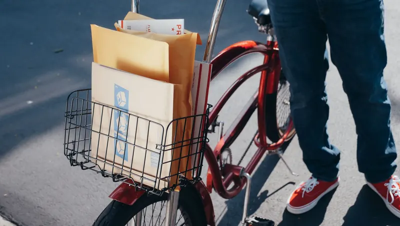 A bicycle with packages in the front basket on a sunny day, ready for delivery