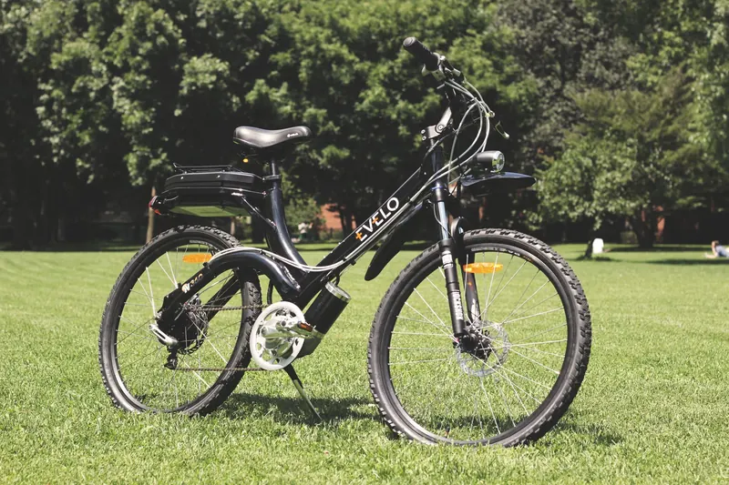 A stylish electric bike parked on lush green grass under the sunny sky