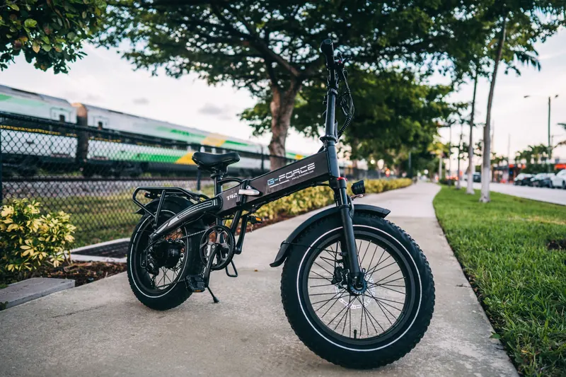 Compact foldable electric bike parked on an urban sidewalk, showcasing modern transportation