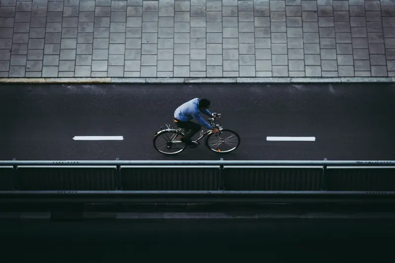 Aerial view of a cyclist riding in a designated bicycle lane on a city road